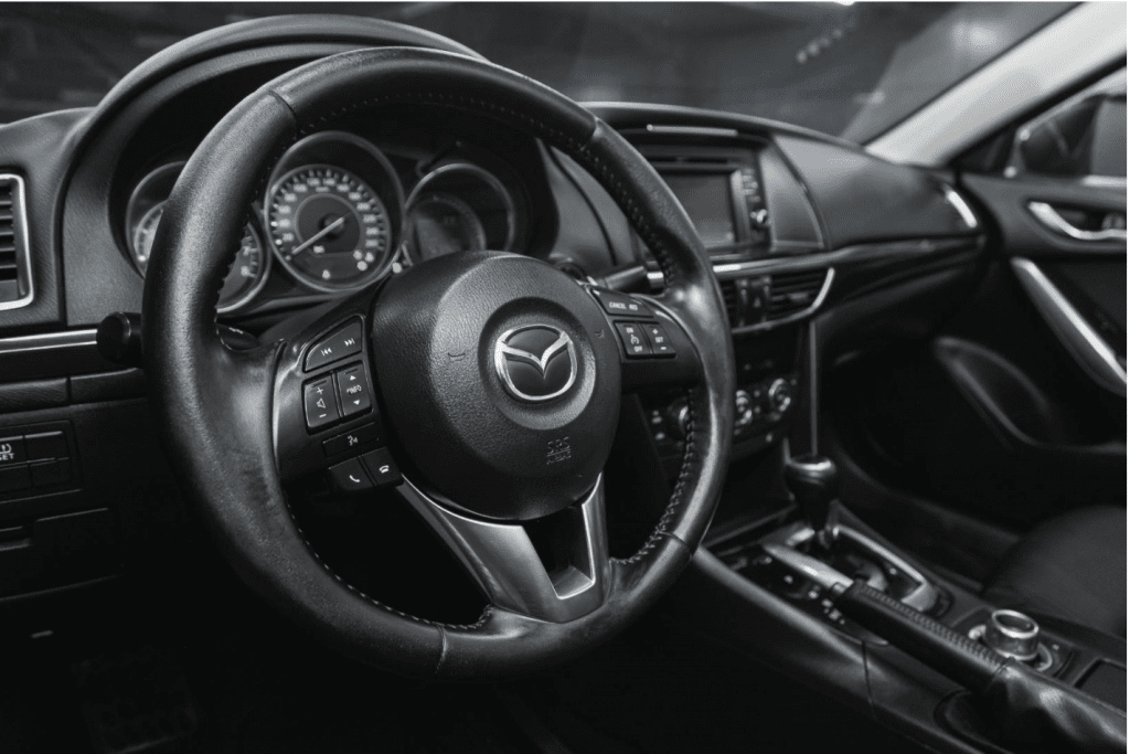 Mazda Car badge on steering wheel with dashboard in background